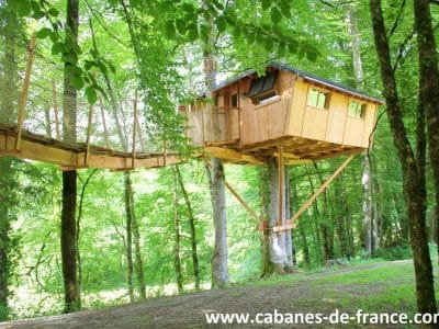 Cabane perchée dans les arbres, entourée de verdure en Bourgogne-Franche-Comté.