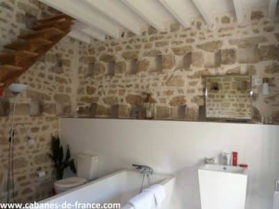 Hébergement insolite en Limousin : salle de bain moderne avec murs en pierre apparente.