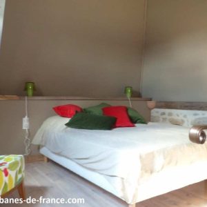Cottage insolite à Limousin avec lit douillet et coussins colorés.