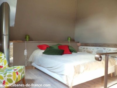 Cottage insolite à Limousin avec lit douillet et coussins colorés.