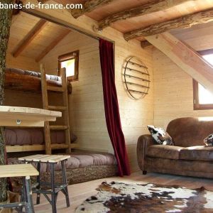 Cabane en bois dans les arbres, avec un arbre traversant lintérieur et un coin salon.