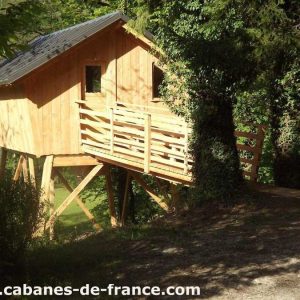 Cabane perchée en bois, entourée darbres verdoyants en Bourgogne-Franche-Comté.