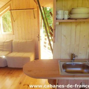 Cabane en bois à Bourgogne-Franche-Comté, avec un coin salon et cuisine intégrée.