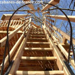 Cabane dans les arbres en Aquitaine, accès par un escalier en bois.