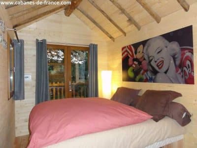 Chalet en bois cosy en Aquitaine, avec une décoration murale colorée et moderne.