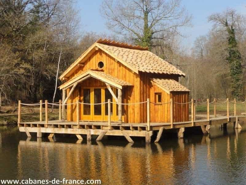 Cabane en bois sur pilotis, entourée deau, offrant un cadre naturel apaisant.