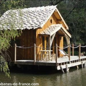 Cabane sur pilotis en bois, entourée deau et de verdure, idéale pour un séjour unique.