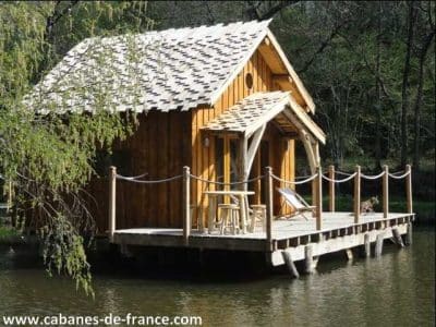 Cabane sur pilotis en bois, entourée deau et de verdure, idéale pour un séjour unique.