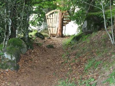 Cabane perchée en Auvergne, nichée entre arbres et rochers, offrant un cadre naturel.