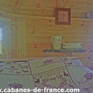 Cabane en bois en Auvergne, avec une décoration chaleureuse et un lit douillet.