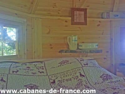 Cabane en bois en Auvergne, avec une décoration chaleureuse et un lit douillet.