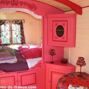 Charmante roulotte colorée en Bretagne, avec des fleurs et un lit douillet.