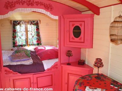 Charmante roulotte colorée en Bretagne, avec des fleurs et un lit douillet.