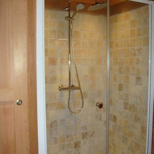 Douche moderne en bois dans un hébergement insolite en Corse.