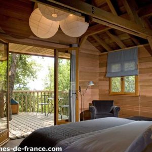 Cabane en bois en Corse, avec un balcon et une vue sur la nature environnante.