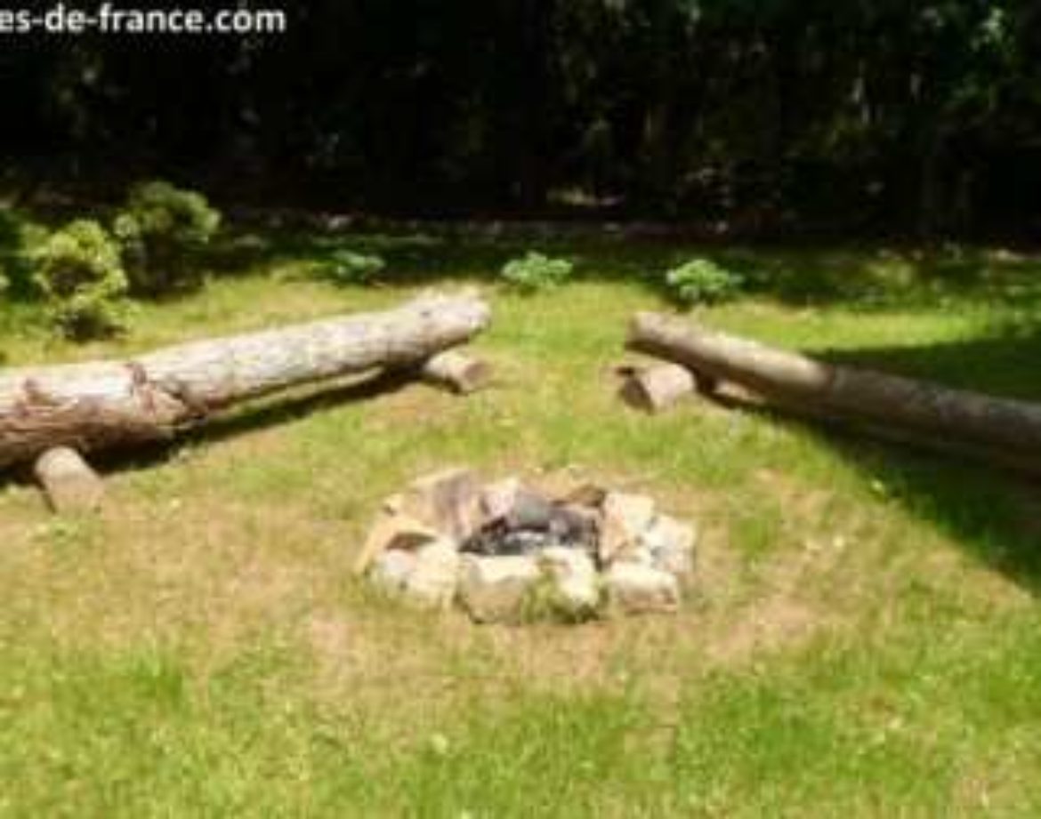 Hébergement insolite en Bretagne : cabane en bois avec un coin feu en plein air.