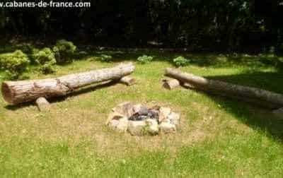 Hébergement insolite en Bretagne : cabane en bois avec un coin feu en plein air.