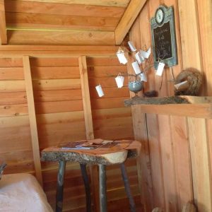 Cabane en bois chaleureuse avec un mobilier en bois brut et une décoration naturelle.