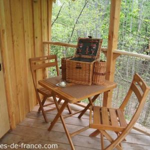 Cabane perchée en Auvergne-Rhône-Alpes avec terrasse en bois et panier pique-nique.