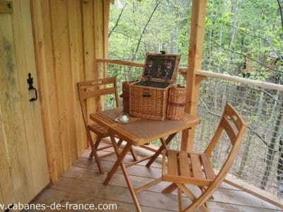 Cabane perchée en Auvergne-Rhône-Alpes avec terrasse en bois et panier pique-nique.