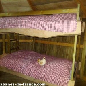 Cabane en bois à Champagne-Ardenne avec lits superposés et décor champêtre.