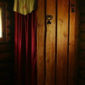 Cabane en bois en Bourgogne, avec rideaux rouges et ambiance chaleureuse.
