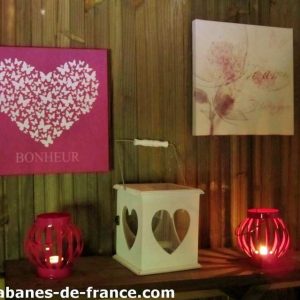Cabanes en bois à Champagne-Ardennes, décor romantique avec lanternes et tableaux.