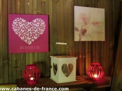 Cabanes en bois à Champagne-Ardennes, décor romantique avec lanternes et tableaux.