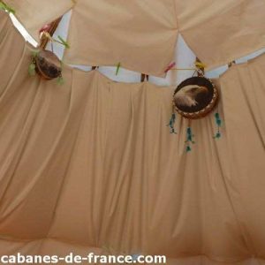 Tente tipi en Bourgogne, intérieur décoré avec des tambours et des éléments colorés.