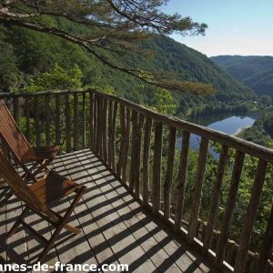 Cabane perchée avec vue panoramique sur la vallée et le lac, idéale pour se ressourcer.