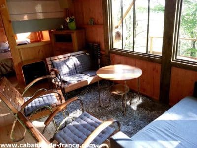 Cabane en bois à Midi-Pyrénées, avec un intérieur chaleureux et lumineux.
