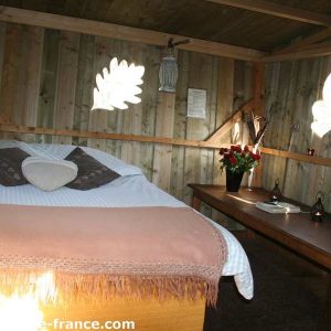 Chalet en bois cosy avec lit douillet et décor naturel à Basse-Normandie.