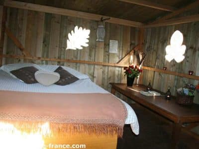 Chalet en bois cosy avec lit douillet et décor naturel à Basse-Normandie.