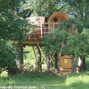 Cabane dans les arbres en Basse-Normandie, perchée entre les feuillages verdoyants.
