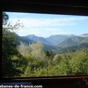 Cabane en bois avec vue panoramique sur les montagnes dAuvergne-Rhône-Alpes.