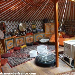 Yourte colorée en Auvergne-Rhône-Alpes, décorée avec des meubles traditionnels.