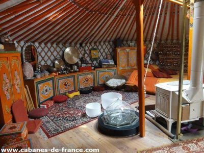 Yourte colorée en Auvergne-Rhône-Alpes, décorée avec des meubles traditionnels.