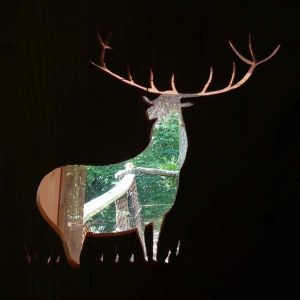 Cabane dans les arbres en Midi-Pyrénées avec une fenêtre en forme de cerf.
