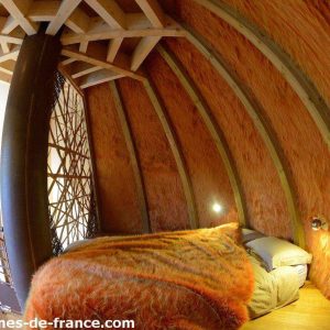 Cabane en bois dans les Pays de la Loire, avec murs en bois chaleureux et lit douillet.