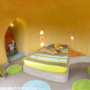 Hébergement insolite en Pays de la Loire : chambre ronde aux murs colorés et lit douillet.