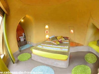 Hébergement insolite en Pays de la Loire : chambre ronde aux murs colorés et lit douillet.