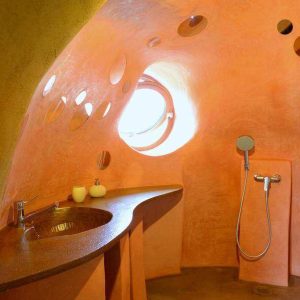 Salle de bain dune cabane insolite en Pays de la Loire, aux murs arrondis et colorés.