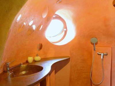 Salle de bain dune cabane insolite en Pays de la Loire, aux murs arrondis et colorés.