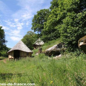 Cabanes en bois au cœur de la nature, entourées de verdure et de rochers.