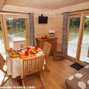 Cabane sur pilotis en Aquitaine, avec vue sur le lac et mobilier en bois chaleureux.