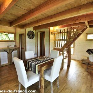 Cabane en bois à Midi-Pyrénées, avec un intérieur chaleureux et un escalier en bois.