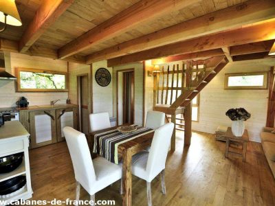 Cabane en bois à Midi-Pyrénées, avec un intérieur chaleureux et un escalier en bois.