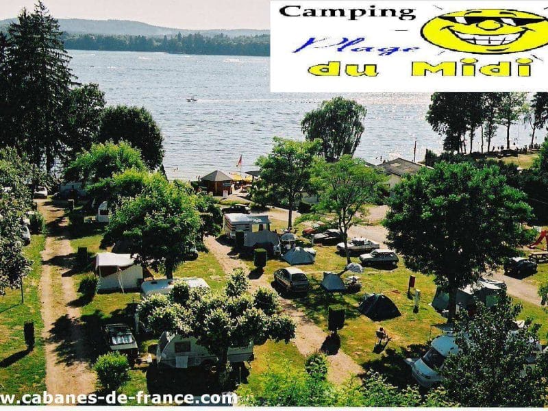 Camping au bord dun lac, entouré darbres et de tentes colorées.
