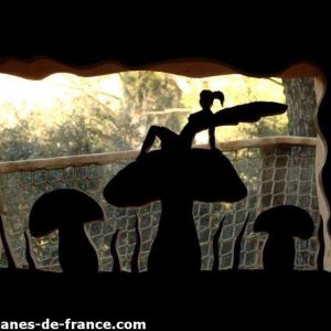 Cabane insolite en forme de champignon, vue originale sur la nature environnante.