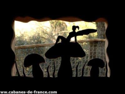 Cabane insolite en forme de champignon, vue originale sur la nature environnante.